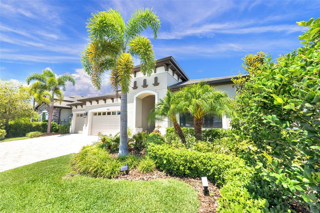 An aerial view of a suburban house with a paved driveway and a backyard lake — 14610 RED CASTLE AVE, LITHIA, FL