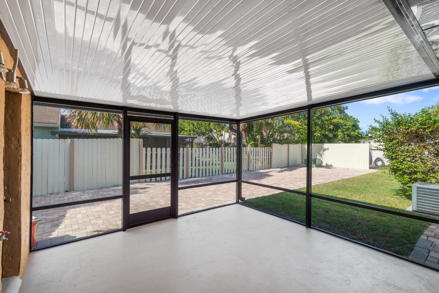 A screened-in patio with a white ceiling, concrete floor, and a view of the backyard — 4619 Gladiator Circle, FL 33463, FL