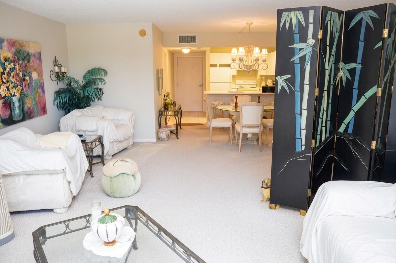 A living room with white slipcovered furniture, a glass coffee table, and a bamboo screen — 2301 Collins Avenue # 336, Miami Beach FL 33139, MIAMI BEACH, FL