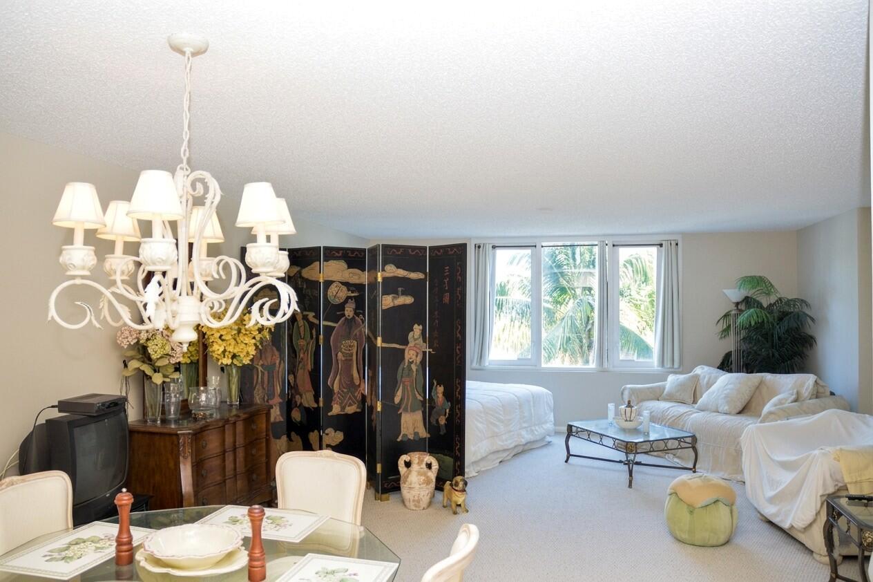 A combined living and bedroom area features a folding screen, white furniture, and a chandelier — 2301 Collins Avenue # 336, Miami Beach FL 33139, MIAMI BEACH, FL