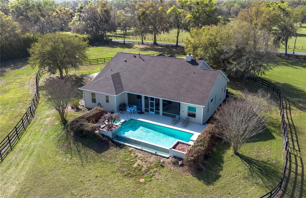 An aerial view of a house with a swimming pool and fenced yard — 8785 NW 63RD STREET, OCALA, FL