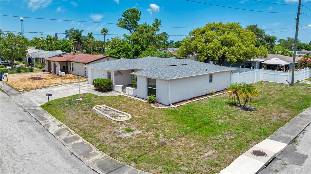 An aerial view shows a single-story house with a gray roof and a white exterior — 3401 SUPREME DRIVE, HOLIDAY, FL