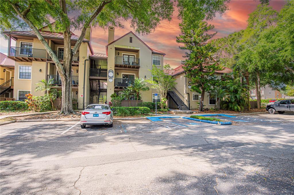 A three-story apartment building with balconies and a parking lot in the foreground — 200 AFTON SQUARE UNIT 108, ALTAMONTE SPRINGS, FL