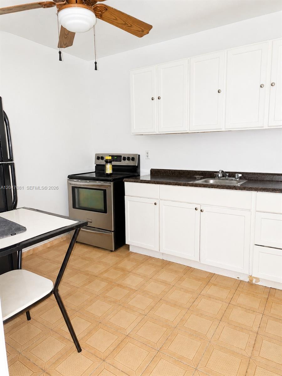 A kitchen features white cabinets, a stainless steel stove, a sink, and tiled flooring — 5810 W Flagler St # 3, Miami FL 33144, MIAMI, FL