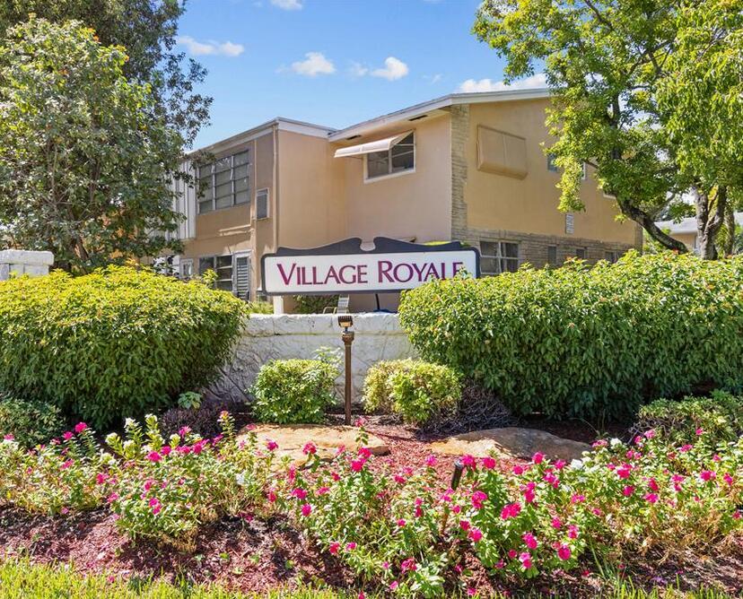 A sign for Village Royale stands in front of a two-story apartment building with landscaping — 2102 NE 1st Way # 103, Boynton Beach FL 33435, BOYNTON BEACH, FL