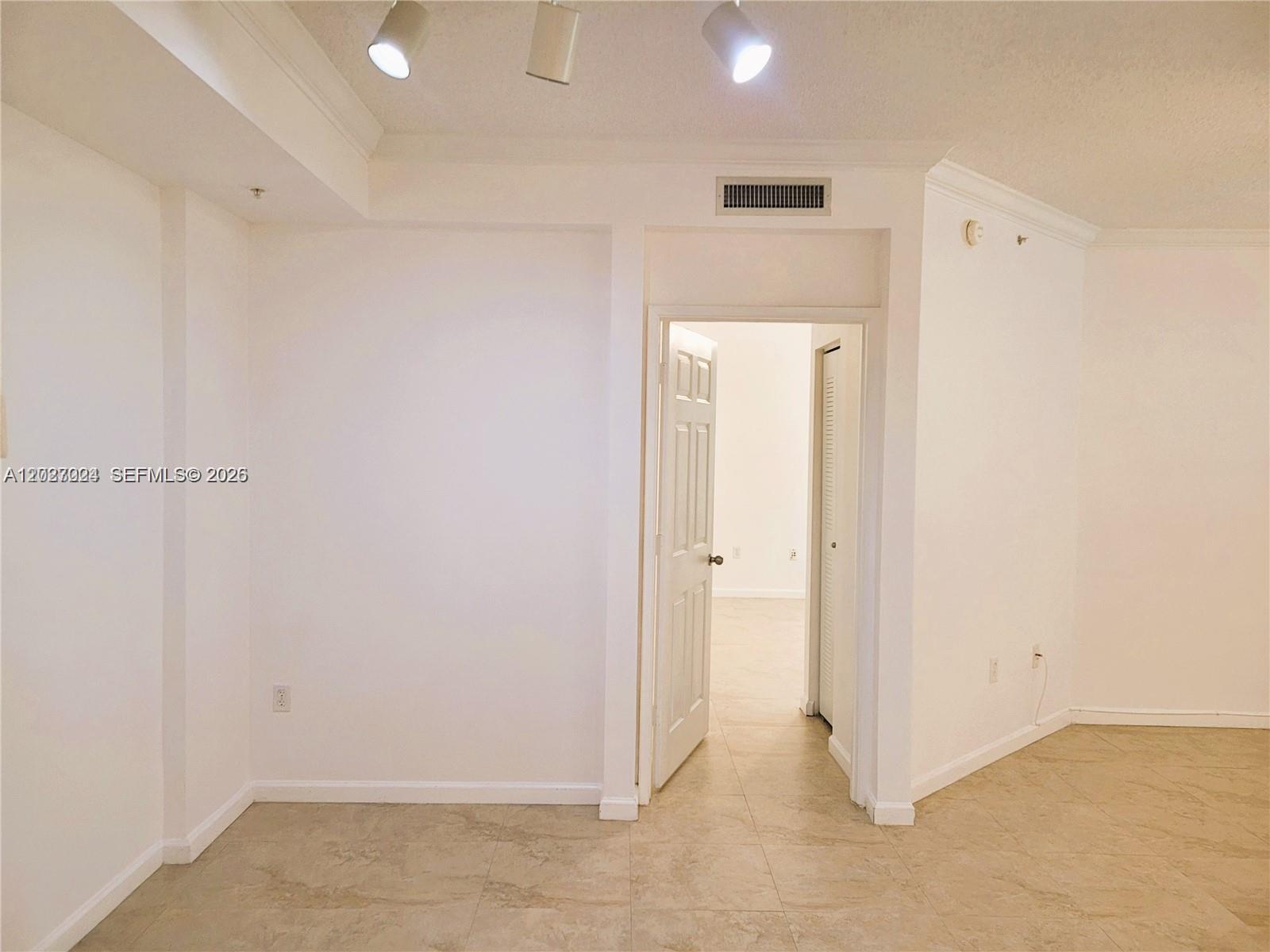 An interior view shows a room with beige tile flooring, white walls, and recessed lighting — 1919 Van Buren St # 111A, Hollywood FL 33020, HOLLYWOOD, FL