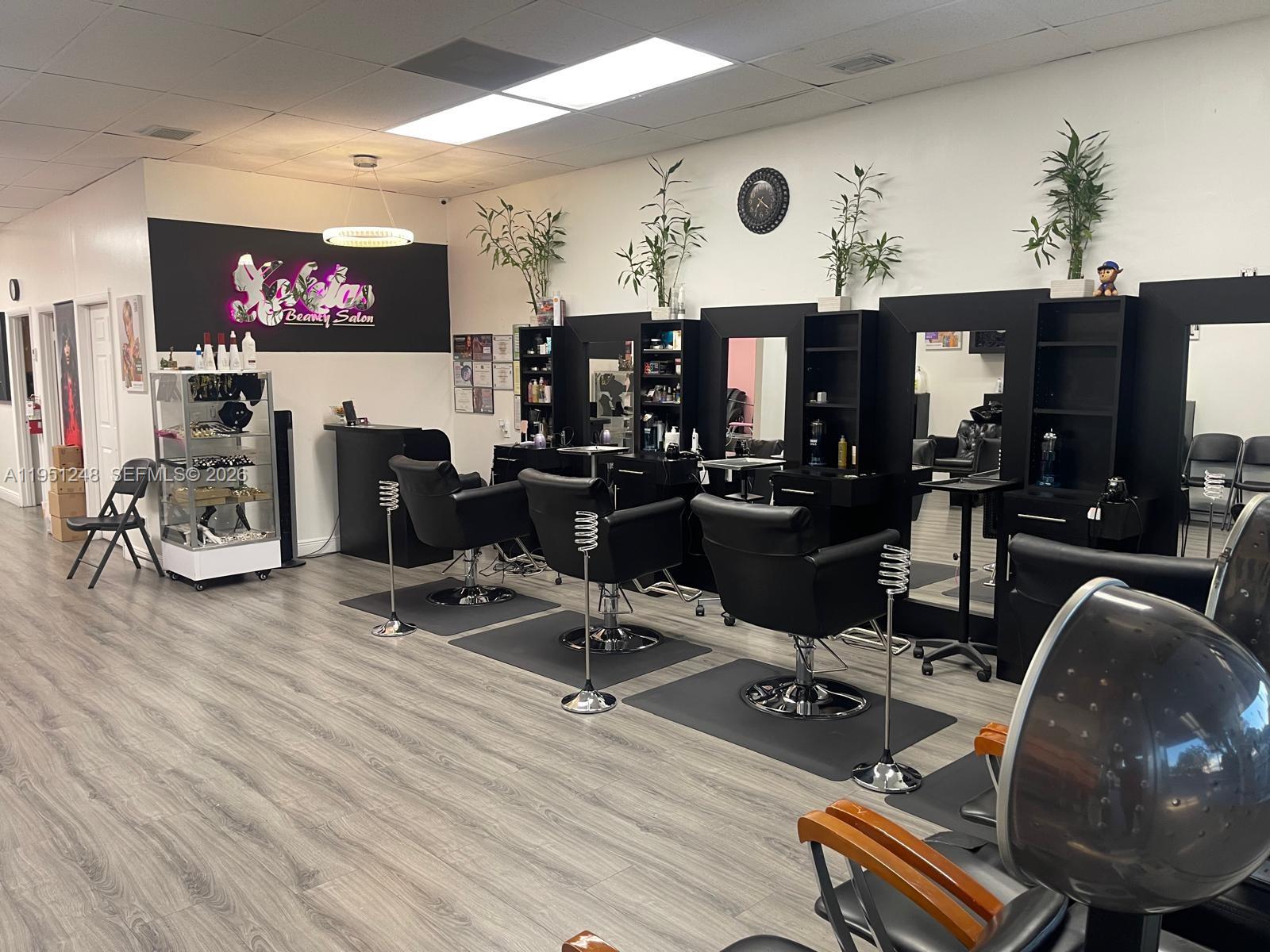 A hair salon features four black styling chairs, workstations with mirrors, and light wood-look flooring — 627 S State Road 7, Hollywood FL 33023, HOLLYWOOD, FL