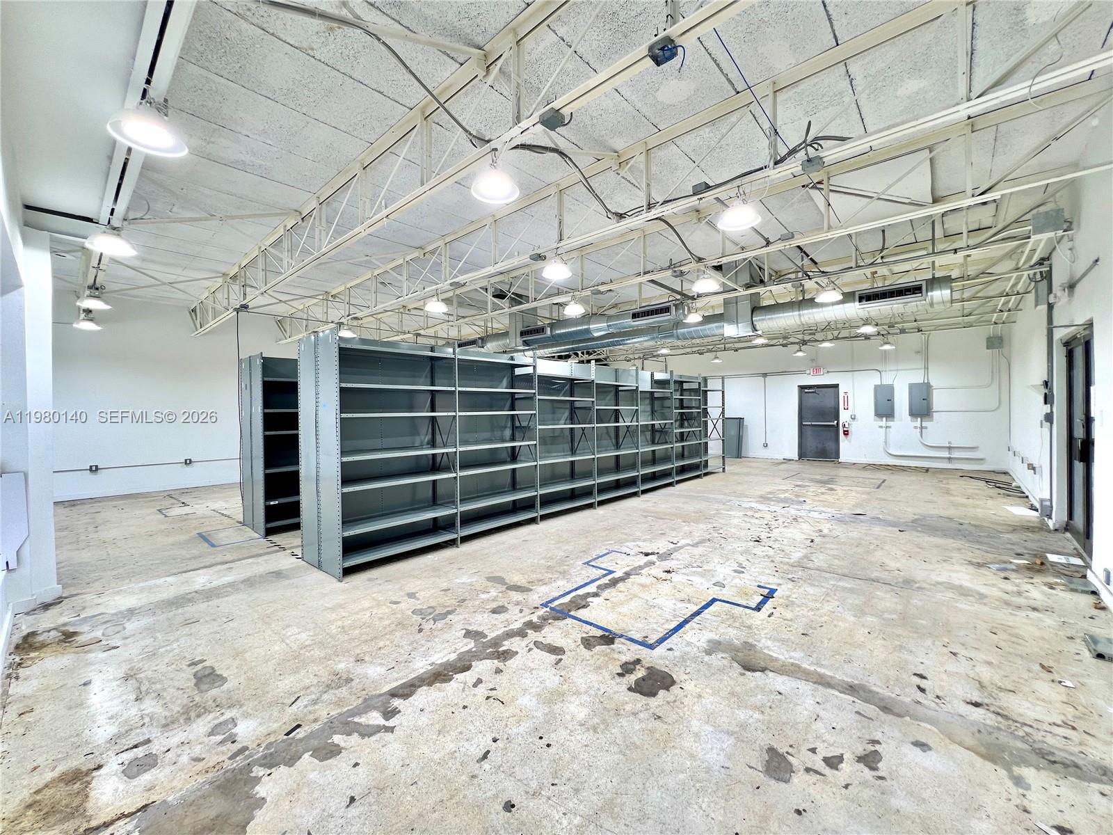 A large, open warehouse space features industrial metal shelving units and a concrete floor — 3390 SW Coral Way, Miami FL 33142, MIAMI, FL
