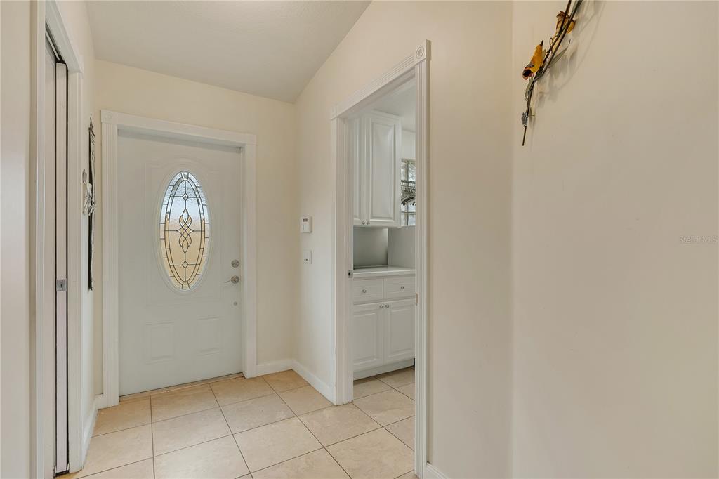 A tiled entryway features a white front door with an oval glass insert and trim — 11831 FAN TAIL LANE, ORLANDO, FL
