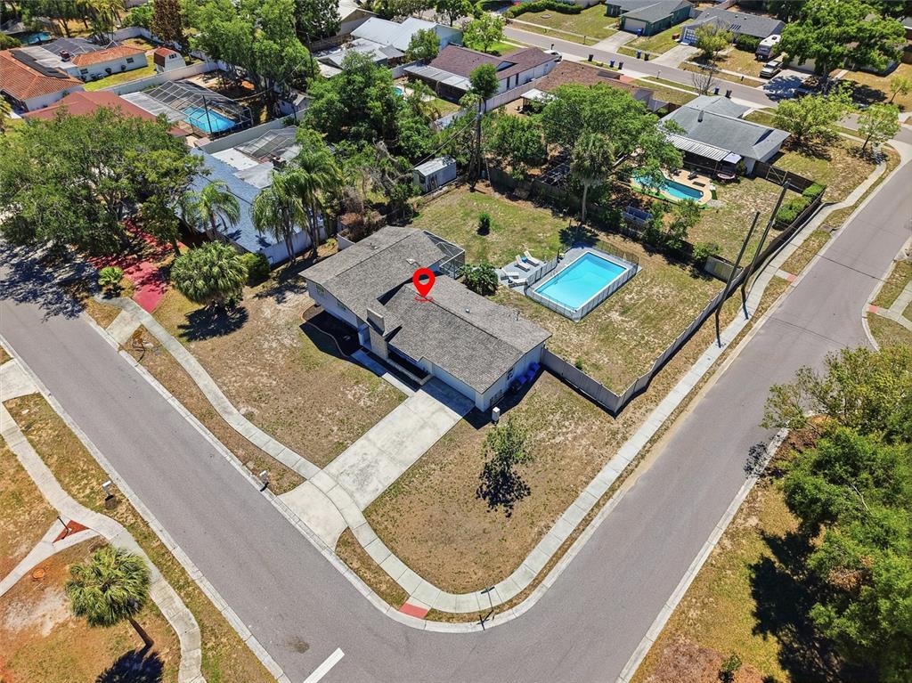 An aerial view shows a single-story house with a swimming pool on a corner lot — 721 VILLAGE PLACE, BRANDON, FL