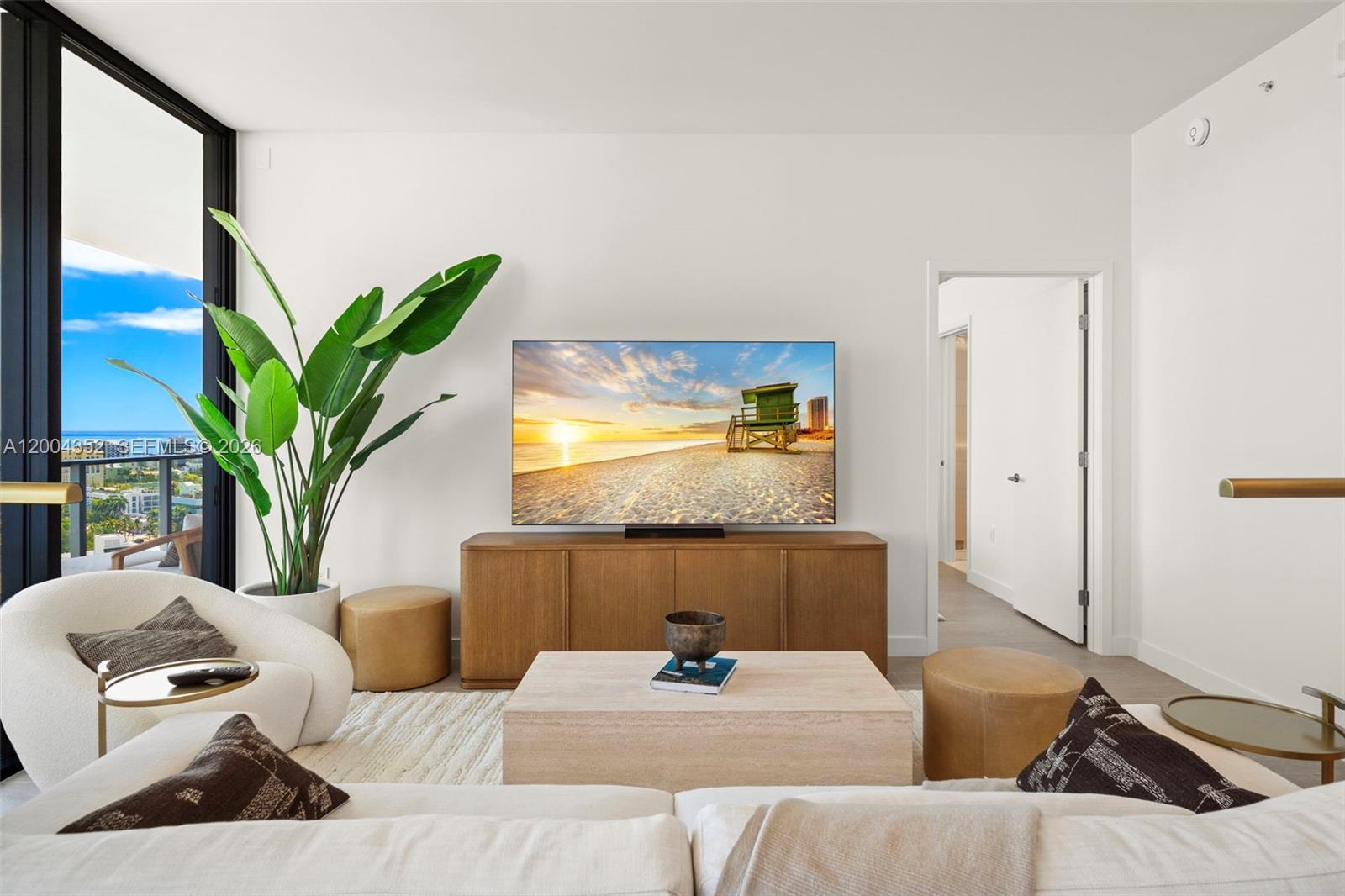 A modern living room features a television on a wooden console, a plant, and seating — 500 Alton Rd # 1707, Miami Beach FL 33139, MIAMI BEACH, FL