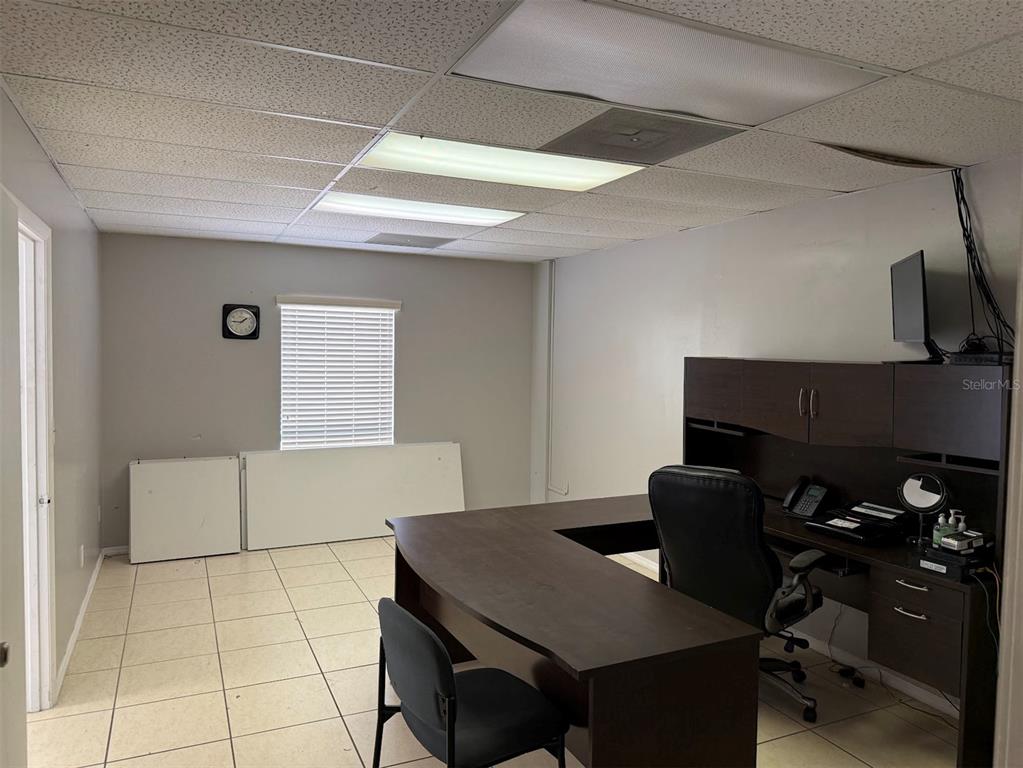 An office with a dark wood desk, a black chair, tile flooring, and a window — 10949 SW 93RD TERRACE UNIT 203, OCALA, FL