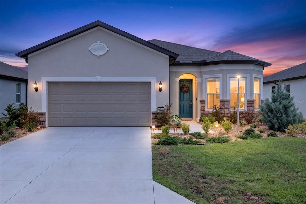 A single-story suburban house with a two-car garage, stone accents, and a teal front door — 8644 SW 59TH LANE ROAD, OCALA, FL