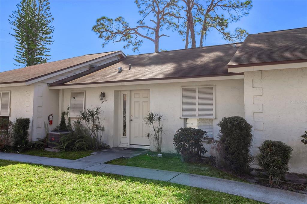 A single-story white stucco house with a brown shingled roof and a front walkway — 5370 ROYAL PALM AVENUE UNIT 5370, SARASOTA, FL