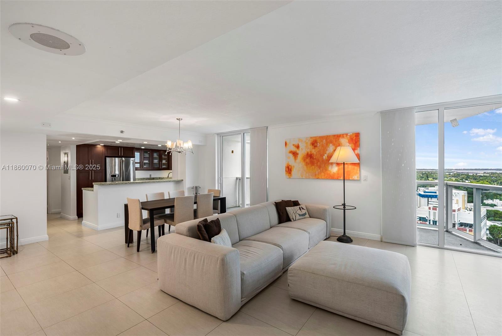 A modern living and dining area features a light-colored sofa, dining set, and balcony views — 2401 Collins Ave # 1808, Miami Beach FL 33140, MIAMI BEACH, FL