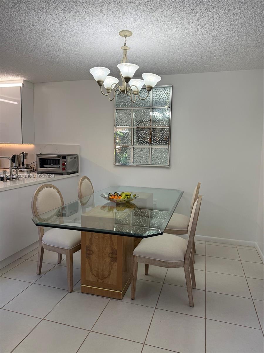 A dining area features a glass-topped table, four upholstered chairs, and a decorative wall mirror — 9101 SW 19th Pl # C, Davie FL 33324, DAVIE, FL