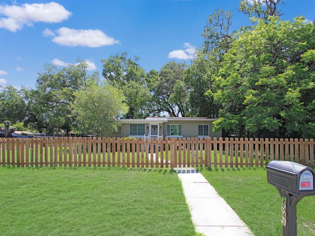 A single-story house with a wooden picket fence and a sidewalk leading to the entrance — 2541 S PALMETTO AVENUE, SANFORD, FL
