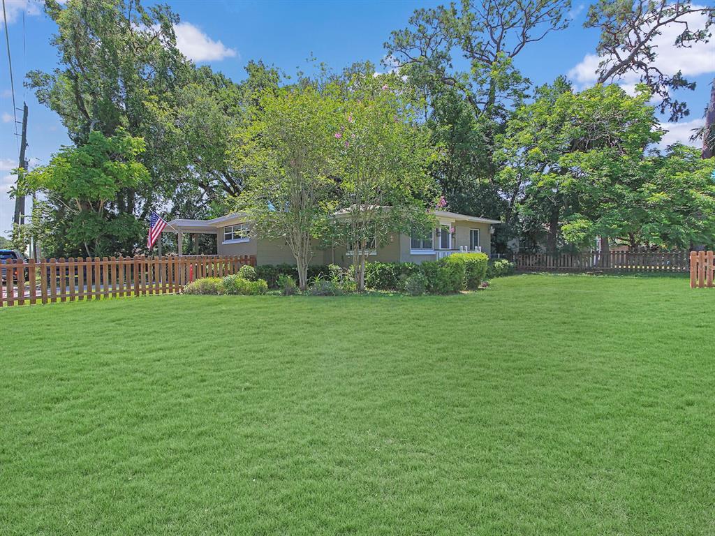 A single-story house with a wooden fence and a large green lawn in front — 2541 S PALMETTO AVENUE, SANFORD, FL