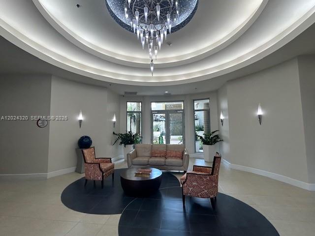 A lobby features a tiered ceiling, a large chandelier, a sofa, and two patterned armchairs — 1830 Radius Dr # 603, Hollywood FL 33020, HOLLYWOOD, FL