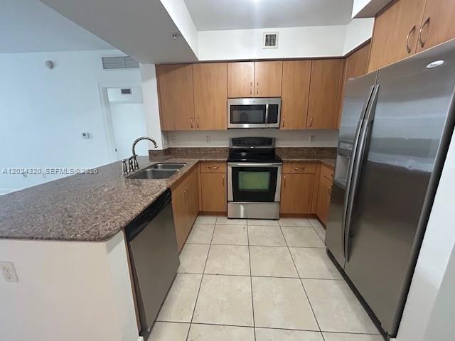 A kitchen features light wood cabinets, granite countertops, stainless steel appliances, and tile flooring — 1830 Radius Dr # 603, Hollywood FL 33020, HOLLYWOOD, FL