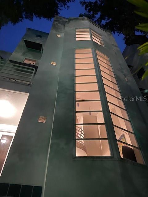 A low-angle exterior view of a modern building featuring a tall, multi-paned vertical window — 4950 BAYSHORE BOULEVARD UNIT 13C, TAMPA, FL