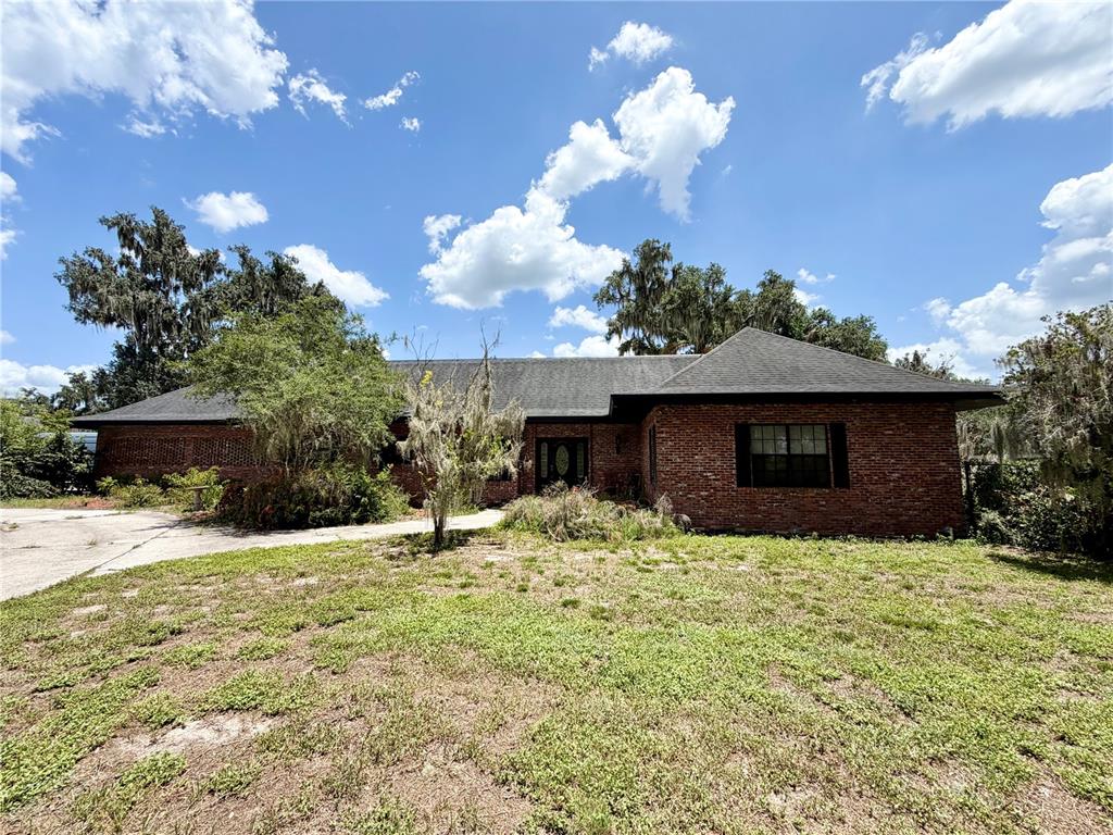 A single-story brick house with a dark shingled roof sits on a grassy lot — 1880 HERMOSA AVENUE, BARTOW, FL
