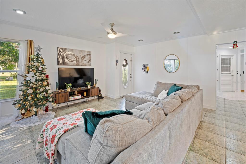A living room features a sectional sofa, a television on a console, and a Christmas tree — 2649 ALBION AVENUE, ORLANDO, FL