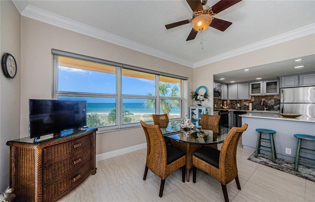 A dining area with a glass table, wicker chairs, and a view of the ocean — 880 MANDALAY AVENUE UNIT S202, CLEARWATER, FL