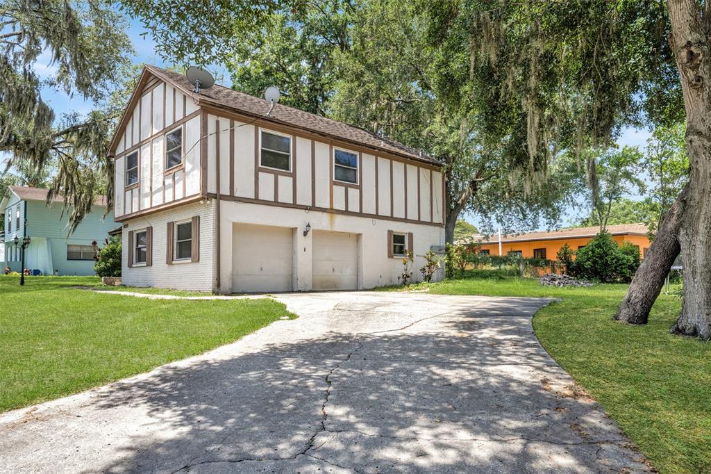 A two-story house with a white brick lower level and timber-framed upper level exterior — 8020 TIERRA VERDE DRIVE, TAMPA, FL