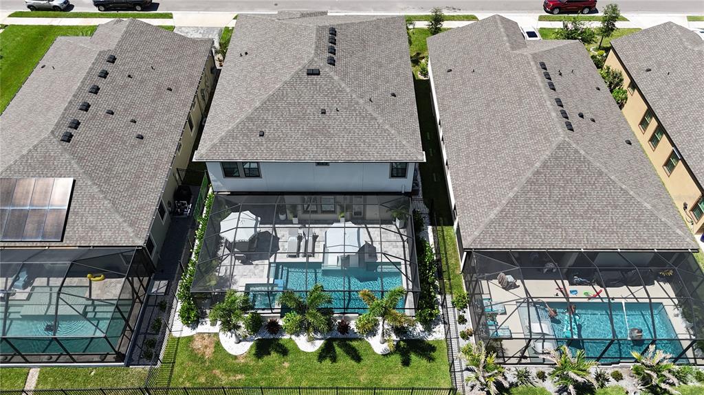 An aerial view shows three houses with screened-in pools and backyards in a residential neighborhood — 13027 HOMESTEAD LANE, PARRISH, FL