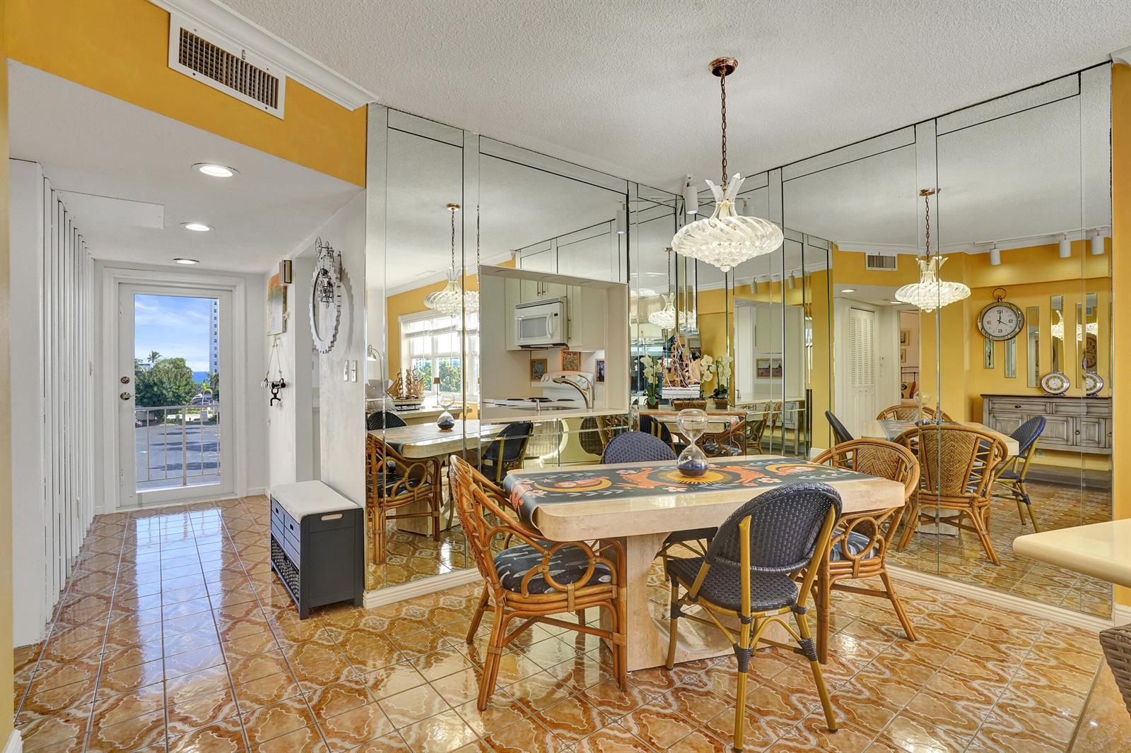 A dining room with a stone table, rattan chairs, mirrored walls, and patterned tile flooring — 1481 S Ocean Boulevard # 412, Pompano Beach FL 33062, POMPANO BEACH, FL
