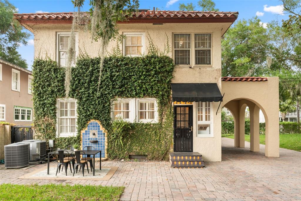 A two-story stucco house with ivy, a tiled fountain, and a covered arched entryway — 732 EDGEWATER DRIVE, ORLANDO, FL