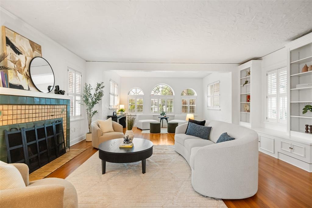 A living room features a tiled fireplace, curved sofa, hardwood floors, and arched windows — 732 EDGEWATER DRIVE, ORLANDO, FL