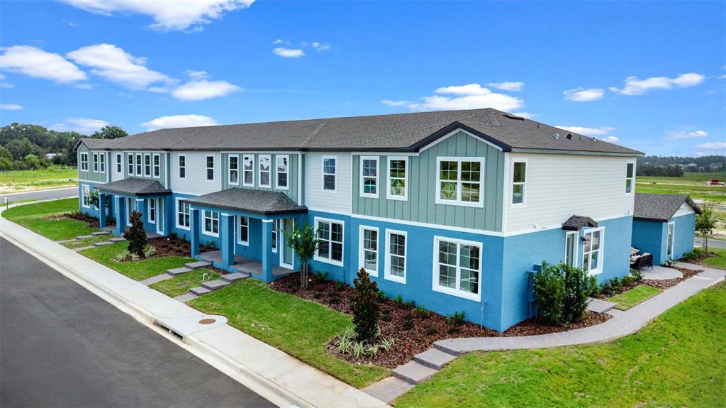 An exterior view of a multi-unit blue and green residential building with a shingled roof — 722 BLISSFUL GARDENS WAY, APOPKA, FL
