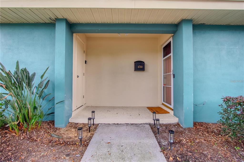 A concrete walkway leads to a covered entryway with a door and a mailbox — 4768 TANGERINE AVENUE UNIT 4768, WINTER PARK, FL