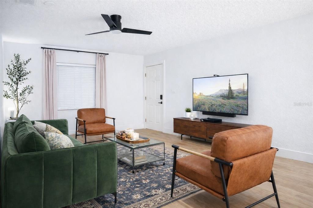 A living room features a green sofa, two leather armchairs, a glass coffee table, and television — 4768 TANGERINE AVENUE UNIT 4768, WINTER PARK, FL
