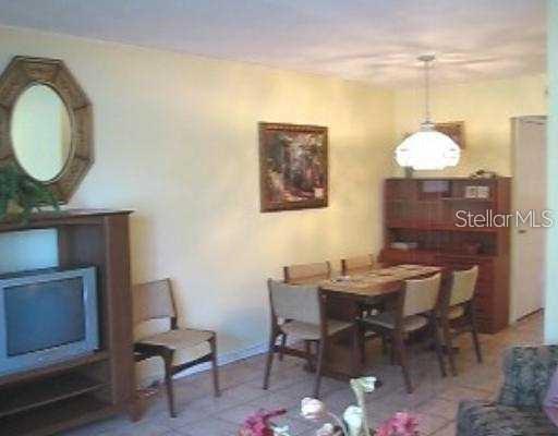 A dining area with a wooden table, chairs, a hutch, and a television stand — 1345 DREW STREET UNIT 5, CLEARWATER, FL