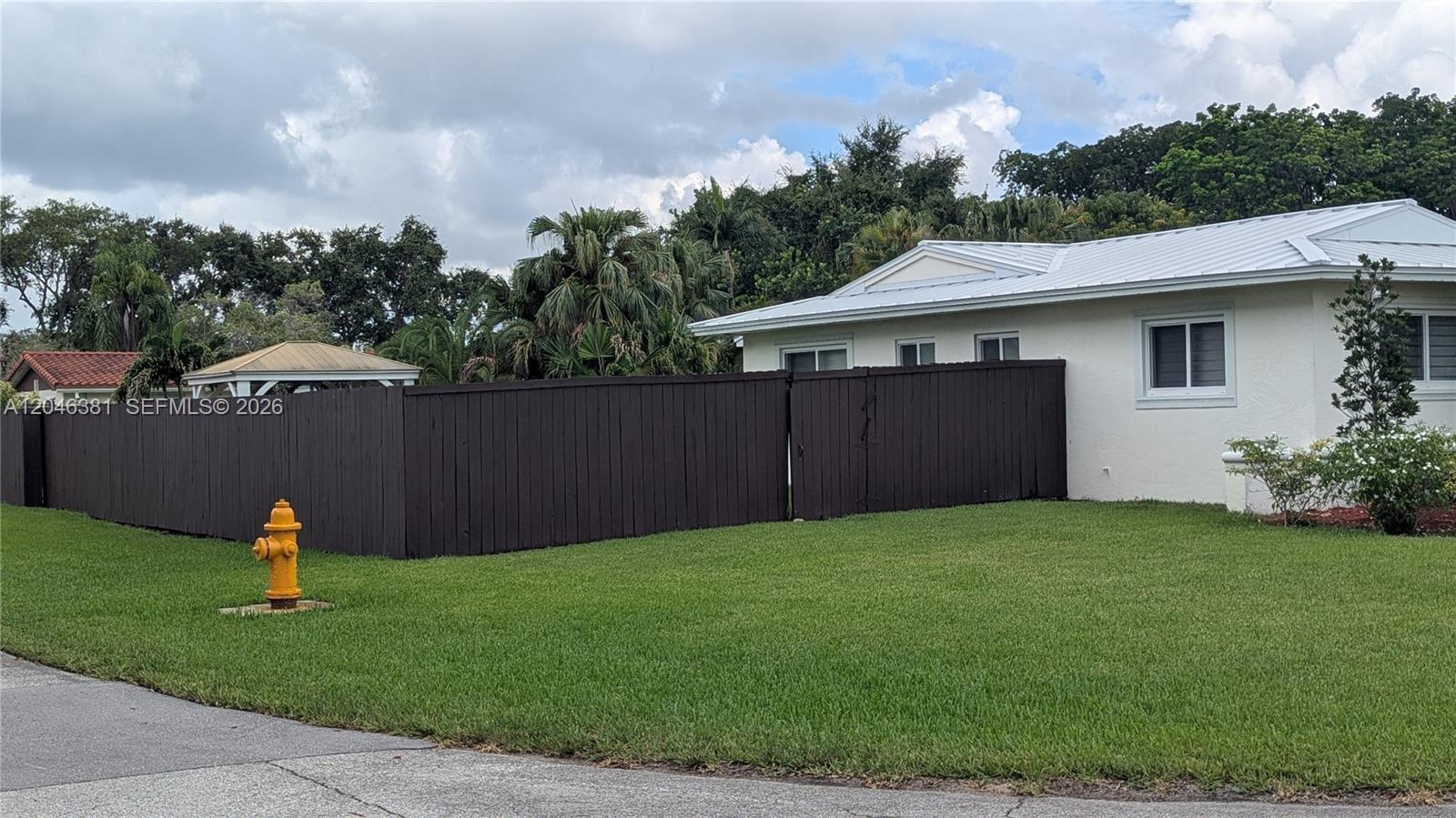 A single-story house with a white metal roof, two-car garage, and arched entryway — 10442 SW 114th St, Miami FL 33176, MIAMI, FL