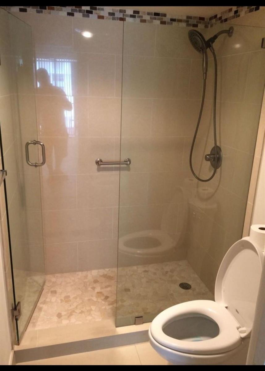 A bathroom features a glass-enclosed walk-in shower with tiled walls and a toilet nearby — 1865 Brickell Avenue # A707, Miami FL 33129, MIAMI, FL