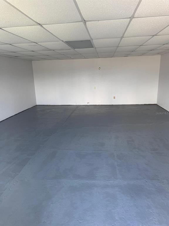 An empty room features a drop ceiling, white walls, and a painted gray concrete floor — 1401 SW MARTIN LUTHER KING JR STREET, ARCADIA, FL