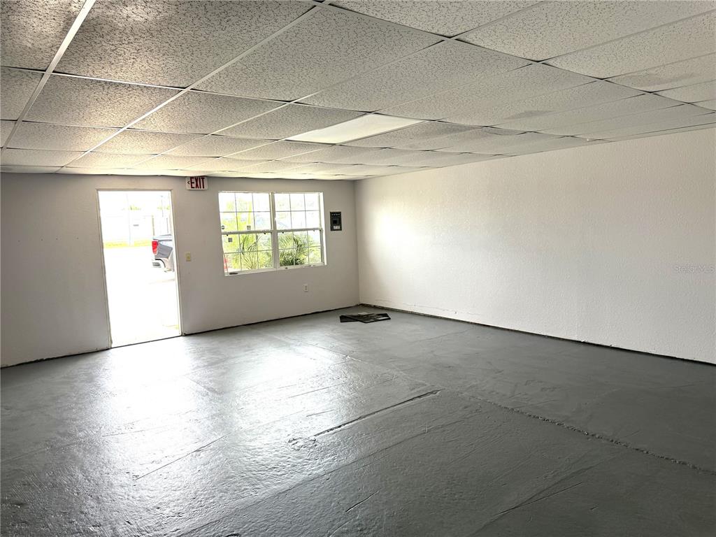 An empty room with a gray painted floor, white walls, and a drop ceiling — 1401 SW MARTIN LUTHER KING JR STREET, ARCADIA, FL