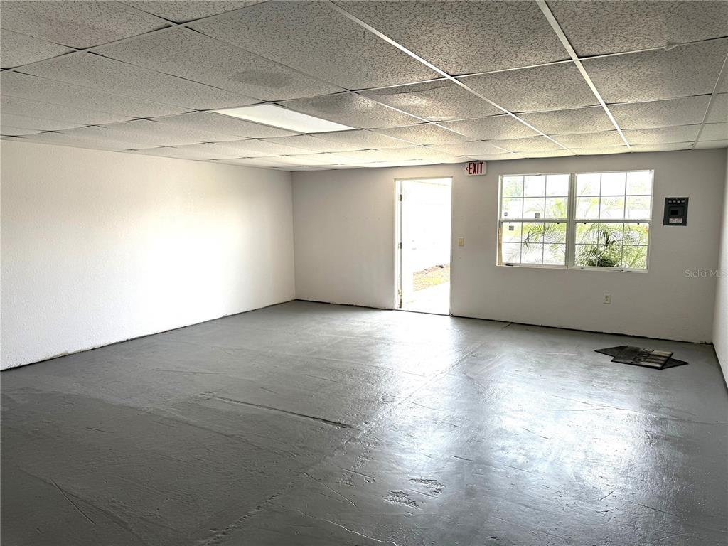 An empty room features a gray concrete floor, white walls, and a drop ceiling — 1401 SW MARTIN LUTHER KING JR STREET, ARCADIA, FL