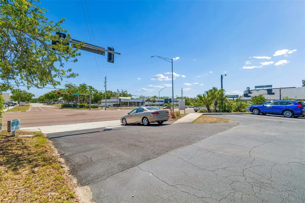 A parking lot sits in front of a street intersection with a blue SUV parked nearby — 7517 LITTLE ROAD, NEW PORT RICHEY, FL