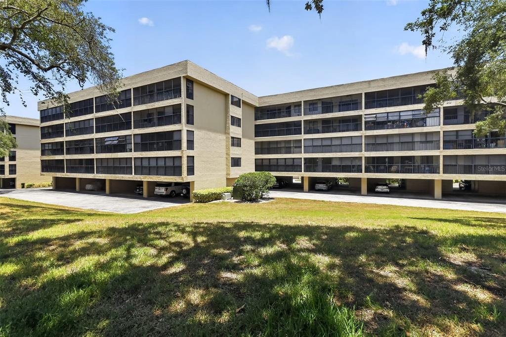 A multi-story apartment building with covered ground-level parking and screened balconies on the upper floors — 1724 GOLFVIEW DRIVE, TARPON SPRINGS, FL