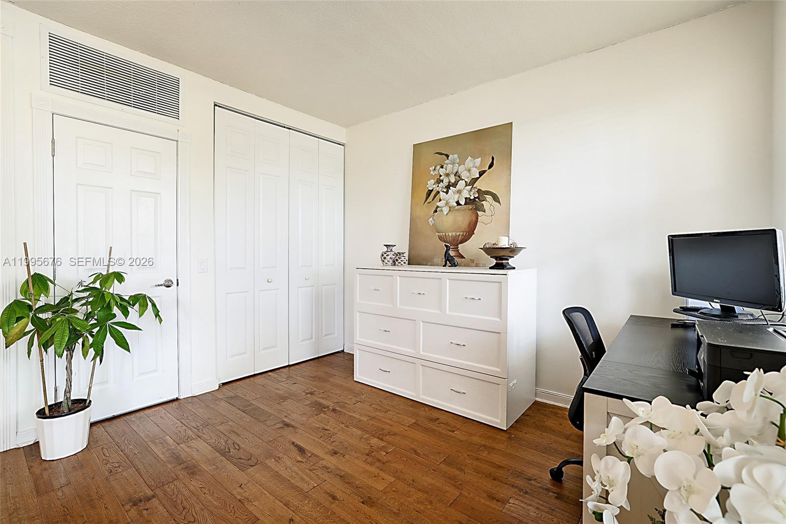 A home office features wood flooring, a white dresser, a desk, and a potted plant — 3414 W Mallory Blvd, Jupiter FL 33458, JUPITER, FL