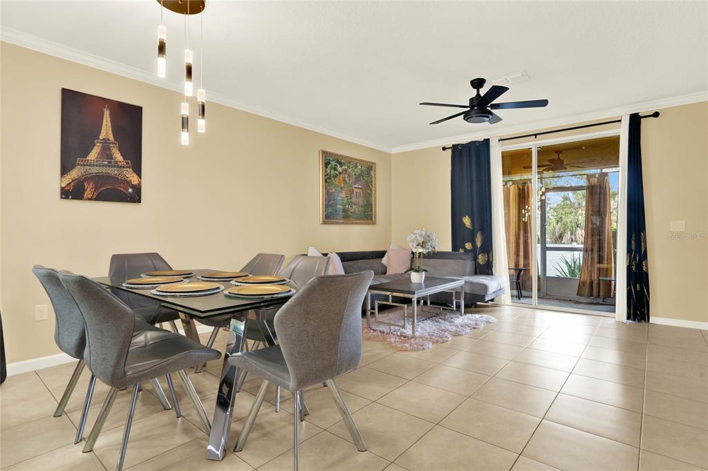 A dining area with a glass table and gray chairs sits beside a living room — 1214 CHELSEA DRIVE, DAVENPORT, FL