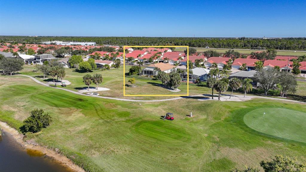 An aerial view shows a house with a screened lanai overlooking a golf course — 3775 TRIPOLI BOULEVARD, PUNTA GORDA, FL