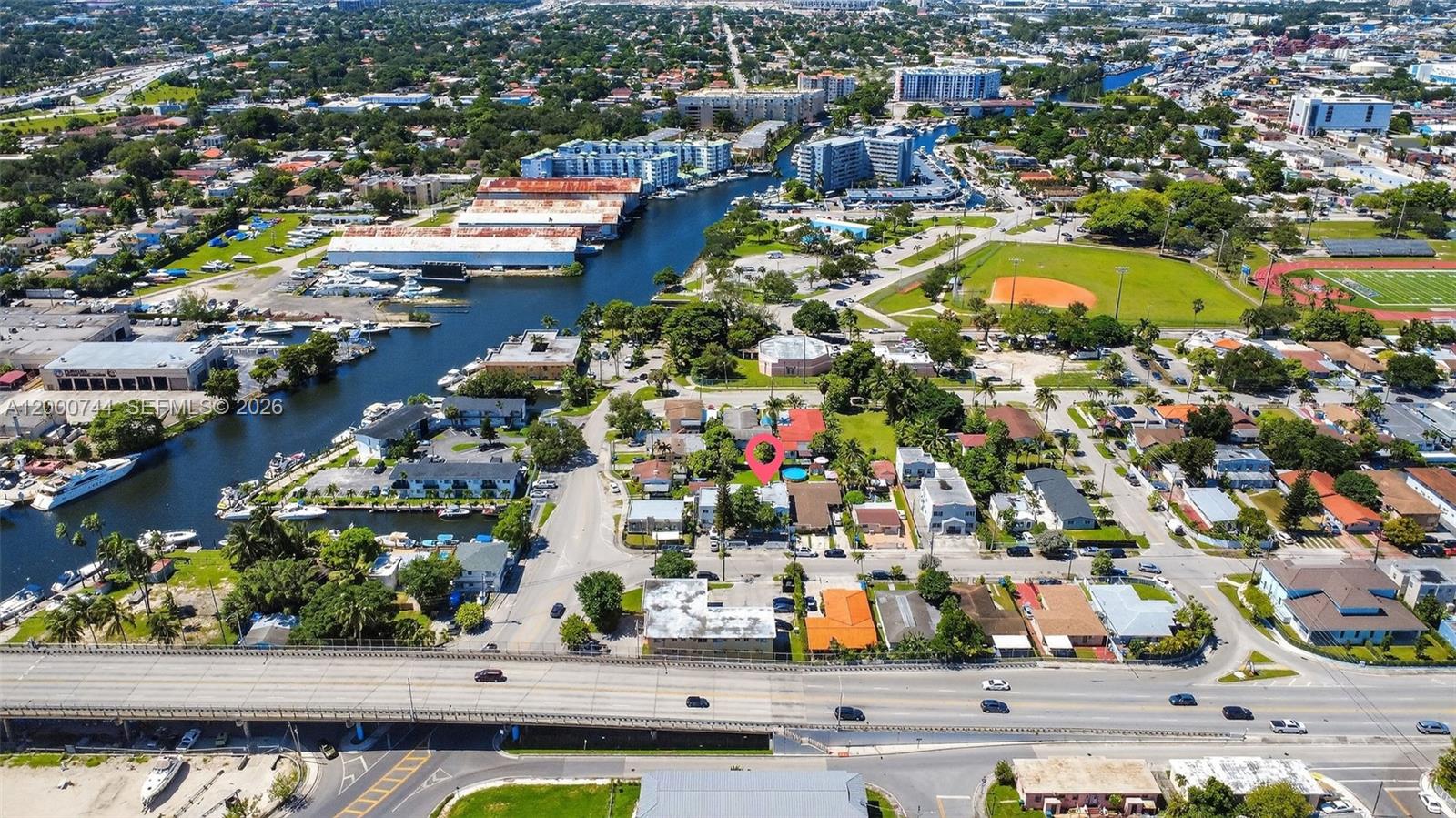 This aerial view shows a residential property marked with a pin near a waterway — 1680 NW 22nd Ct, Miami FL 33125, MIAMI, FL