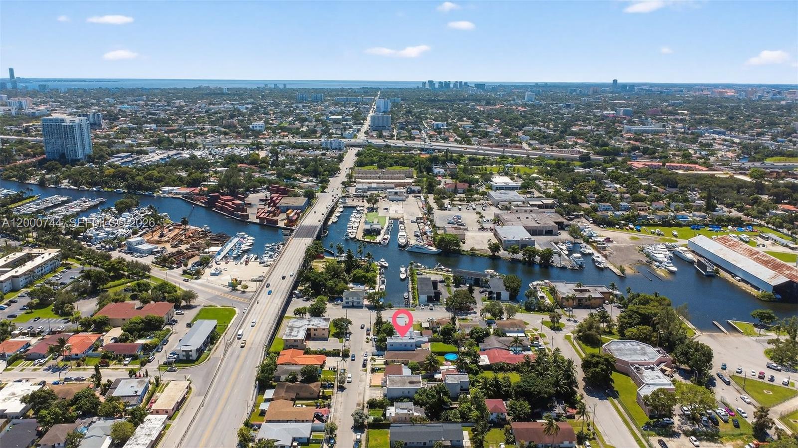 An aerial view shows a residential neighborhood with a canal, a bridge, and a marked property — 1680 NW 22nd Ct, Miami FL 33125, MIAMI, FL