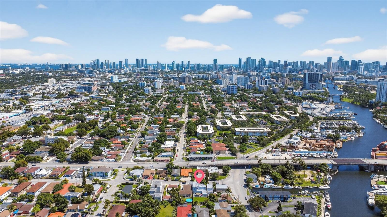 An aerial view shows a residential neighborhood with a pink location pin near a canal — 1680 NW 22nd Ct, Miami FL 33125, MIAMI, FL